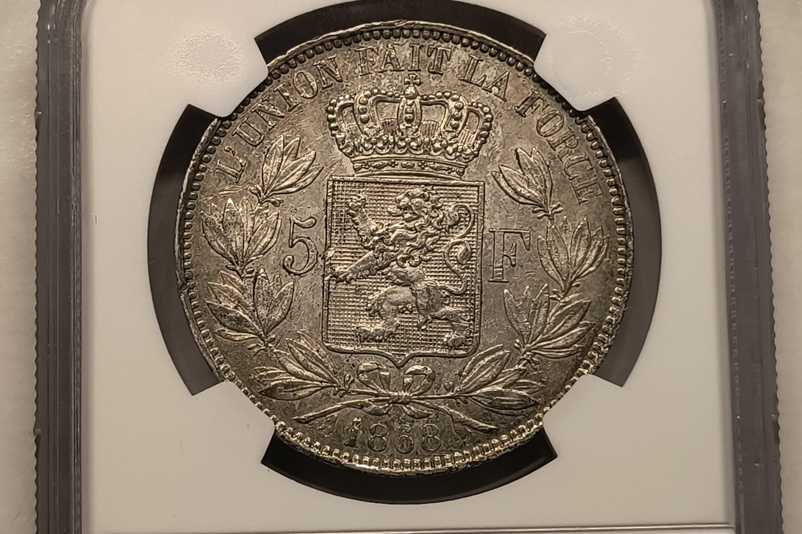 5 Francos Bélgica 1868 – Leopoldo II – Small Head – NGC AU Details · Plata 0,900 · ArgentumSun — Reverso